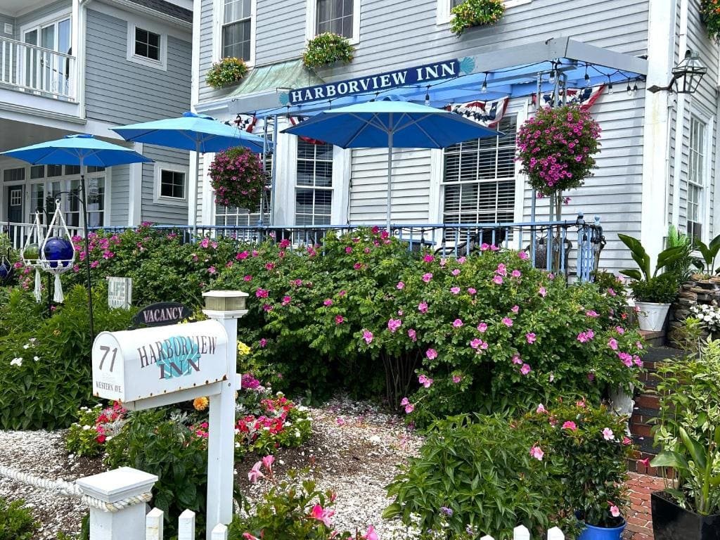 The front porch of the Harborview Inn, blue awnings and flower beds along the walk