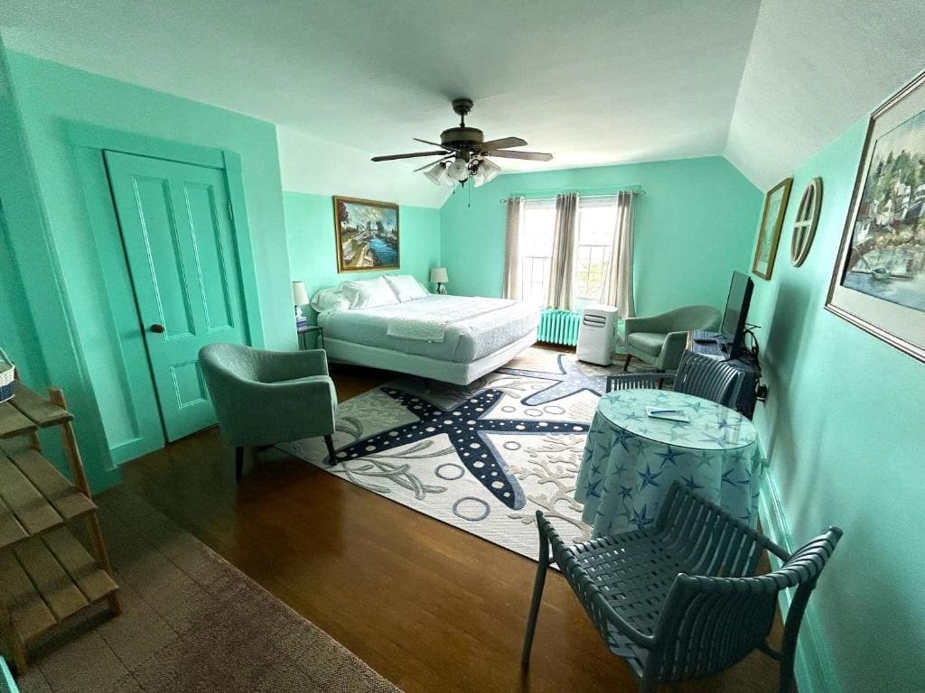 A guest room at the Harborview Inn, mint green walls and a made bed